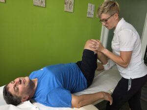 Fisioterapista durante la riabilitazione dopo protesi di ginocchio